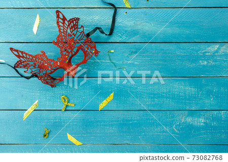 Table top view aerial image of beautiful colorful carnival festival background.Flat lay accessory object the several mask & decor confetti on modern blue wooden at home office desk studio.copy space. 73082768