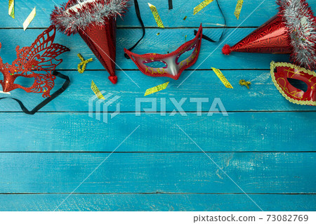 Table top view aerial image of beautiful colorful carnival festival background.Flat lay accessory object the several mask & decor confetti on modern blue wooden at home office desk studio.copy space. 73082769