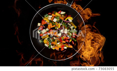 Mix vegetable in pan, flames on background 73083055