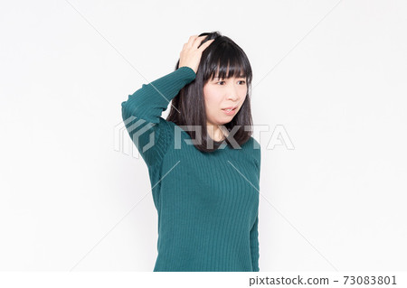 拿著她的頭的婦女站立在白色背景前面 拿著她的頭的婦女站立在白色背景前面 73083801