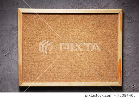 cork board or corkboard at grey concrete wall 73084403