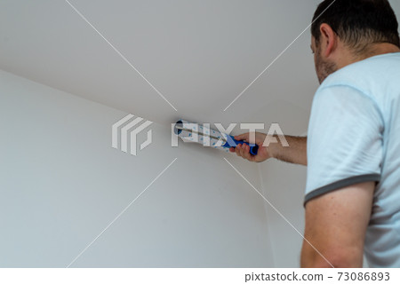 Painting a ceiling in white 73086893