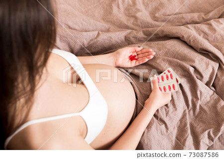 Pregnant woman with pills in hand, healthcare concept, medicine during pregnancy Pregnant woman with pills in hand, healthcare concept, medicine during pregnancy 73087586