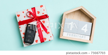 Top view of car key on a gift box with red hearts and festive calendar on colorful background. The fourteenth of february. Present for Valentine's Day concept Top view of car key on a gift box with red hearts and festive calendar on colorful background. The fourteenth of february. Present for Valentine's Day concept 73087703