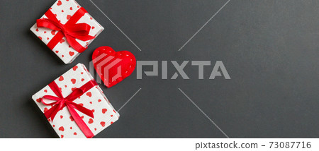 Holiday composition of gift boxes and red textile hearts on colorful background with empty space for your design. Top view of Valentine's Day concept 73087716