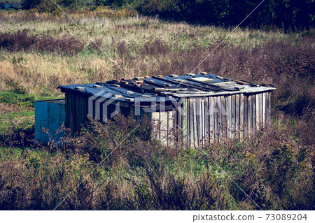 Old weathered wooden hut in the middle of the field Old weathered wooden hut in the middle of the field 73089204