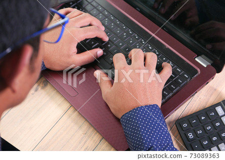 rear view of man hand typing on laptop. 73089363