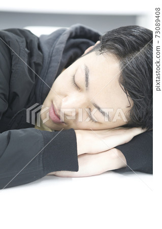 A young man taking a nap 73089408