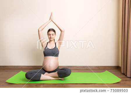 Portrait of young pregnant yoga model working at the home. Pregnancy Yoga and Fitness concept at coronavirus time 73089503