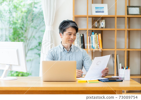 A middle-aged businessman who teleworks A middle-aged businessman who teleworks 73089754