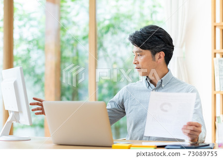 A middle-aged businessman who teleworks A middle-aged businessman who teleworks 73089755