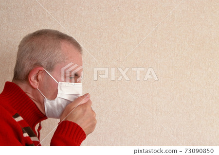 Foreign man wearing a mask and coughing 73090850