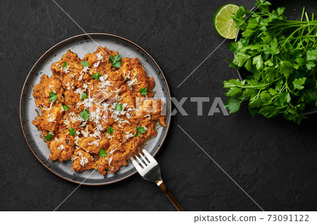 Mangalorean Chicken Sukka on black plate on dark slate table top. Indian cuisine coconut curry dish 73091122