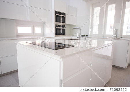 White organised kitchen with modern elements in an apartment White organised kitchen with modern elements in an apartment 73092232
