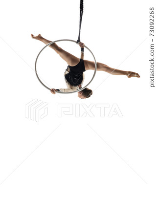 Young female acrobat, circus athlete isolated on white studio background. Training perfect balanced in flight Young female acrobat, circus athlete isolated on white studio background. Training perfect balanced in flight 73092268