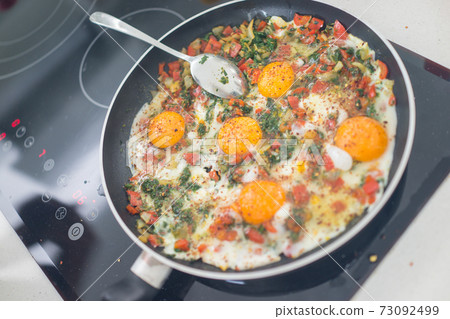 In the course of making breakfast with fresh eggs and vegetables 73092499