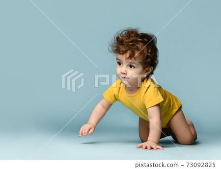 Cute smiling curly baby boy toddler in yellow Cute smiling curly baby boy toddler in yellow 73092825