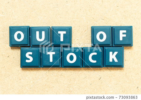 Tile alphabet letter in word out of stock on wood background 73093863