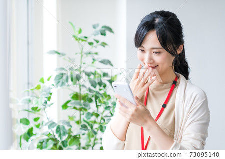 在辦公室使用智能手機的女商人 在辦公室使用智能手機的女商人 73095140