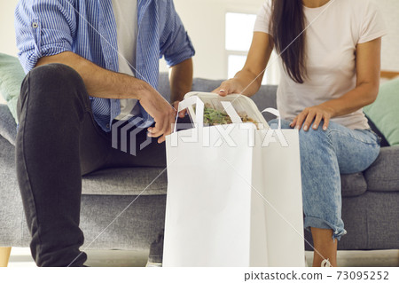 Hands of young couple taking healthy boxed food order out of bag 73095252