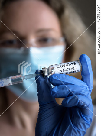 COVID-19 vaccine in doctor`s hand closeup COVID-19 vaccine in doctor`s hand closeup 73095554