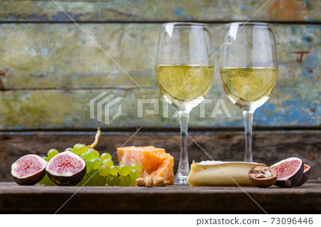 Set of cheese with figs, grapes and white wine 73096446