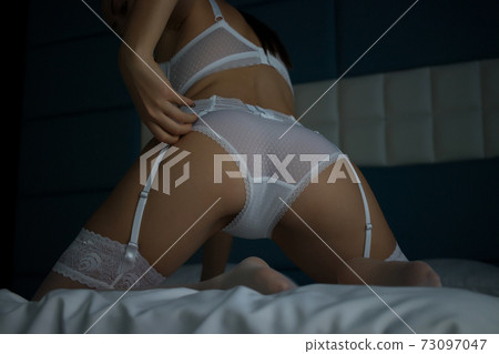 Anonymous woman in erotic white lingerie in bed Anonymous woman in erotic white lingerie in bed 73097047