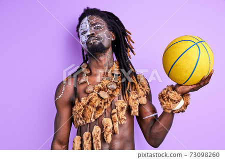 confident afro american pagan male with national make-up holding basketball ball in hands confident afro american pagan male with national make-up holding basketball ball in hands 73098260