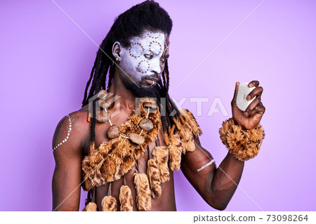 funny shaman tribal male trying to understand how to use modern combs for hair funny shaman tribal male trying to understand how to use modern combs for hair 73098264