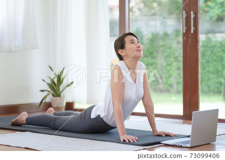Beautiful asian woman staying fit by exercising at home for healthy trend lifestyle 73099406
