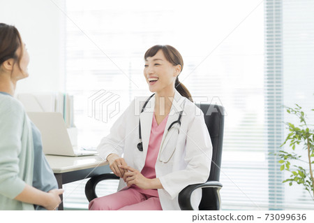 Female doctor examining a pregnant woman 73099636