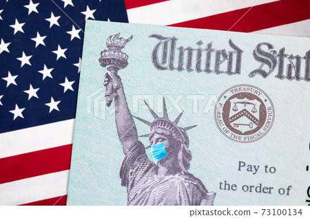 United States IRS Stimulus Check with Statue of Liberty Wearing Medical Face Mask Resting on American Flag 73100134