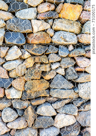 Stone wall with metal grid as background Stone wall with metal grid as background 73100175
