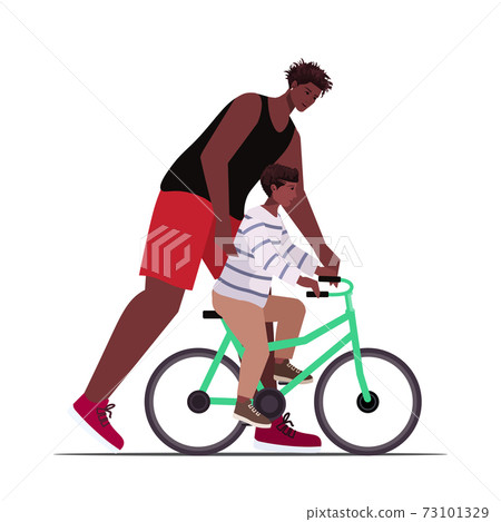 african american father teaching little son to ride bike parenting fatherhood concept dad spending time with kid african american father teaching little son to ride bike parenting fatherhood concept dad spending time with kid 73101329
