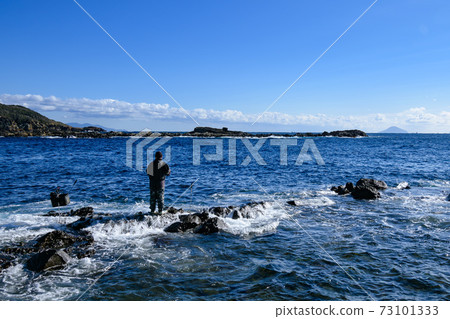 Back view of a man fishing at the beach Back view of a man fishing at the beach 73101333
