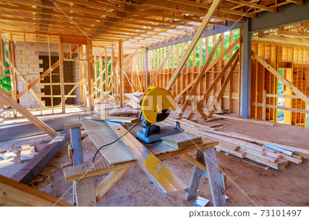 Circular metal saw on new home construction framing of a house under construction 73101497