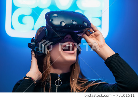 Young female player delighted with the game. Augmented reality. 73101511