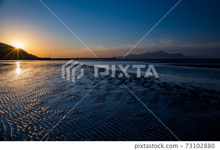 The sunset of the Ariake Sea at dusk dyes the sea on the Moshirai coast 73102880