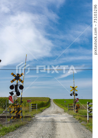 Scenery with wonderful fields and railroad crossings in Hokkaido 73103296