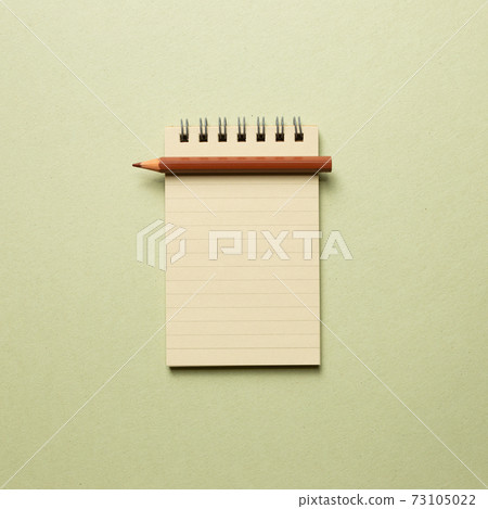 Empty notepad with brown pencil on khaki background. top view, copy space Empty notepad with brown pencil on khaki background. top view, copy space 73105022