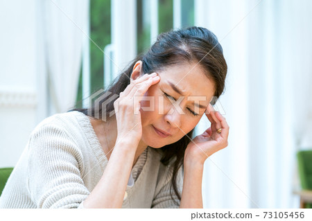 Woman in her 60s with a headache 73105456