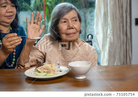 Senior asian woman bored with food. Senior asian woman bored with food. 73105754