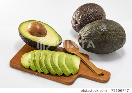 Avocado cut and placed on a mini plate with a white background Avocado cut and placed on a mini plate with a white background 73106747