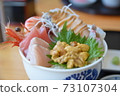 Bowl of rice topped with sashimi  73107304