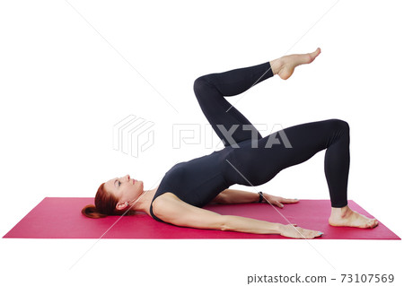 Pilates. Slender woman on the Mat performs the shoulder bridge exercise. Isolated on a white Pilates. Slender woman on the Mat performs the shoulder bridge exercise. Isolated on a white 73107569