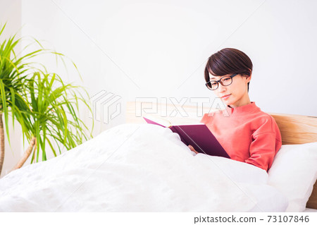 A woman reading in bed A woman reading in bed 73107846