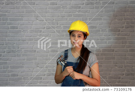 Technician woman ware yellow helmet with grey T-shirt and denim jeans apron dress Technician woman ware yellow helmet with grey T-shirt and denim jeans apron dress 73109176