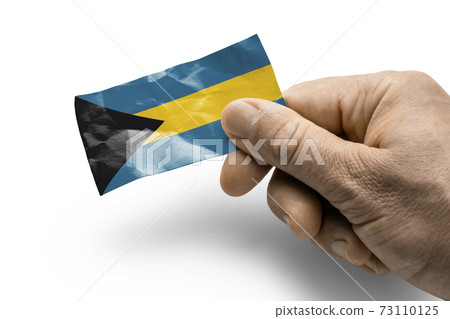 Hand holding a card with a national flag the Bahamas 73110125
