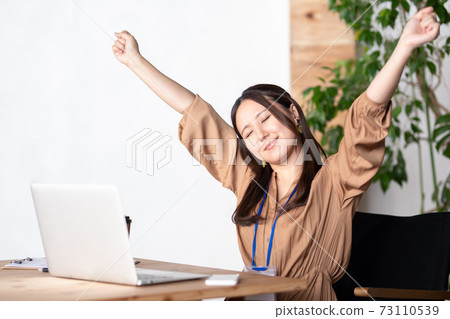 Business woman taking a deep breath in the office Business woman taking a deep breath in the office 73110539