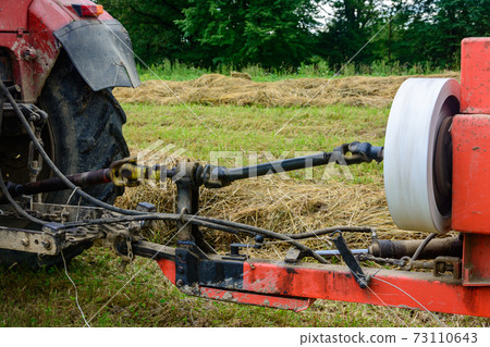 Tractor and cardan shaft for coupling equipment, tractor in the field during haymaking. 73110643